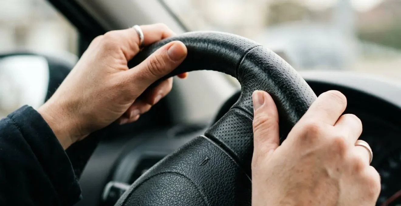 Vue macro d'un volant de voiture avec les mains d'un candidat pendant l'examen du permis